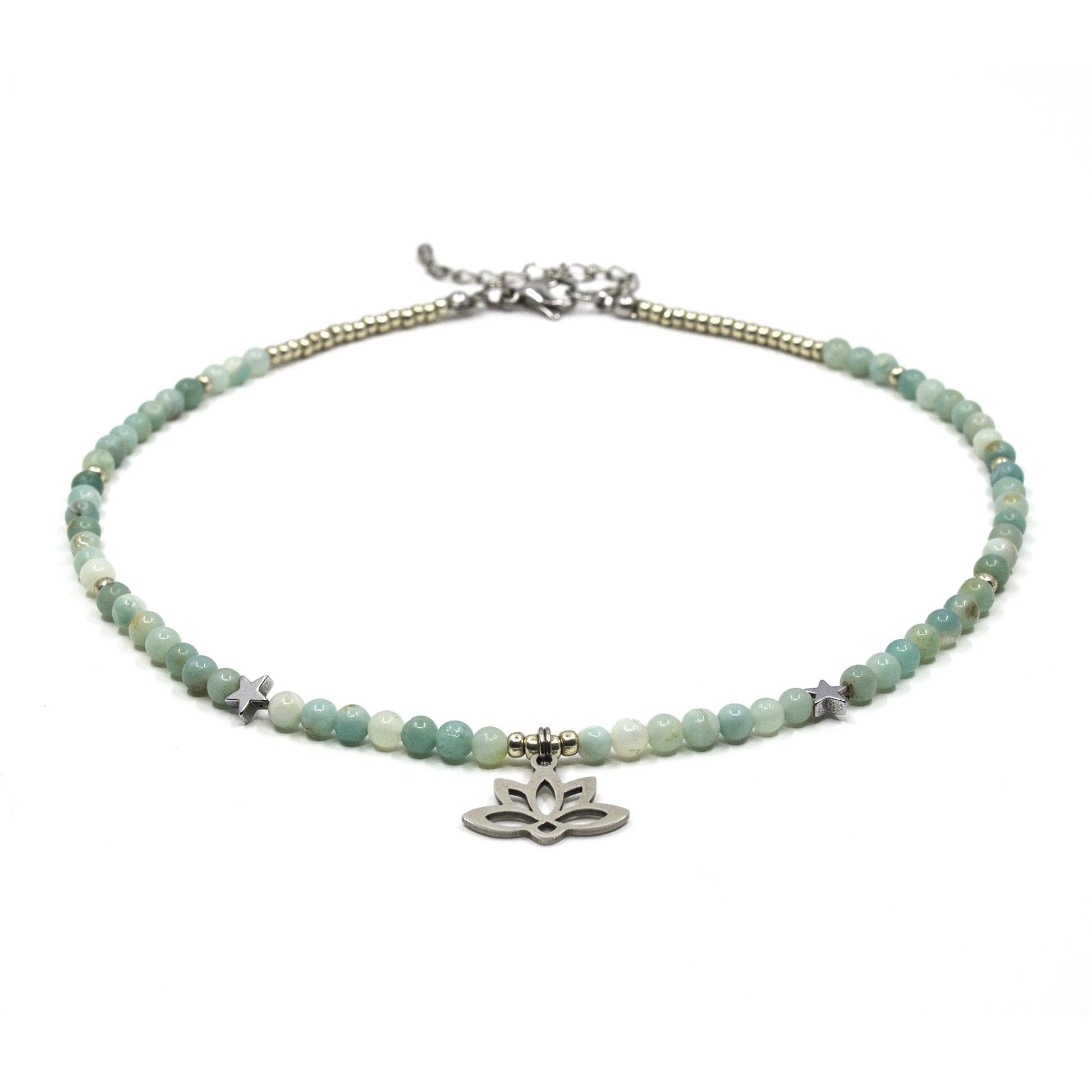 Necklace with green beads and a silver lotus flower charm on a white background